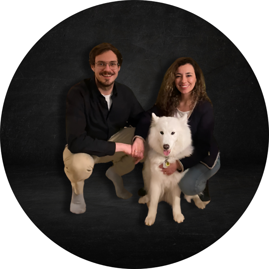 Mann und Frau hocken mit ihrem weisen Hund