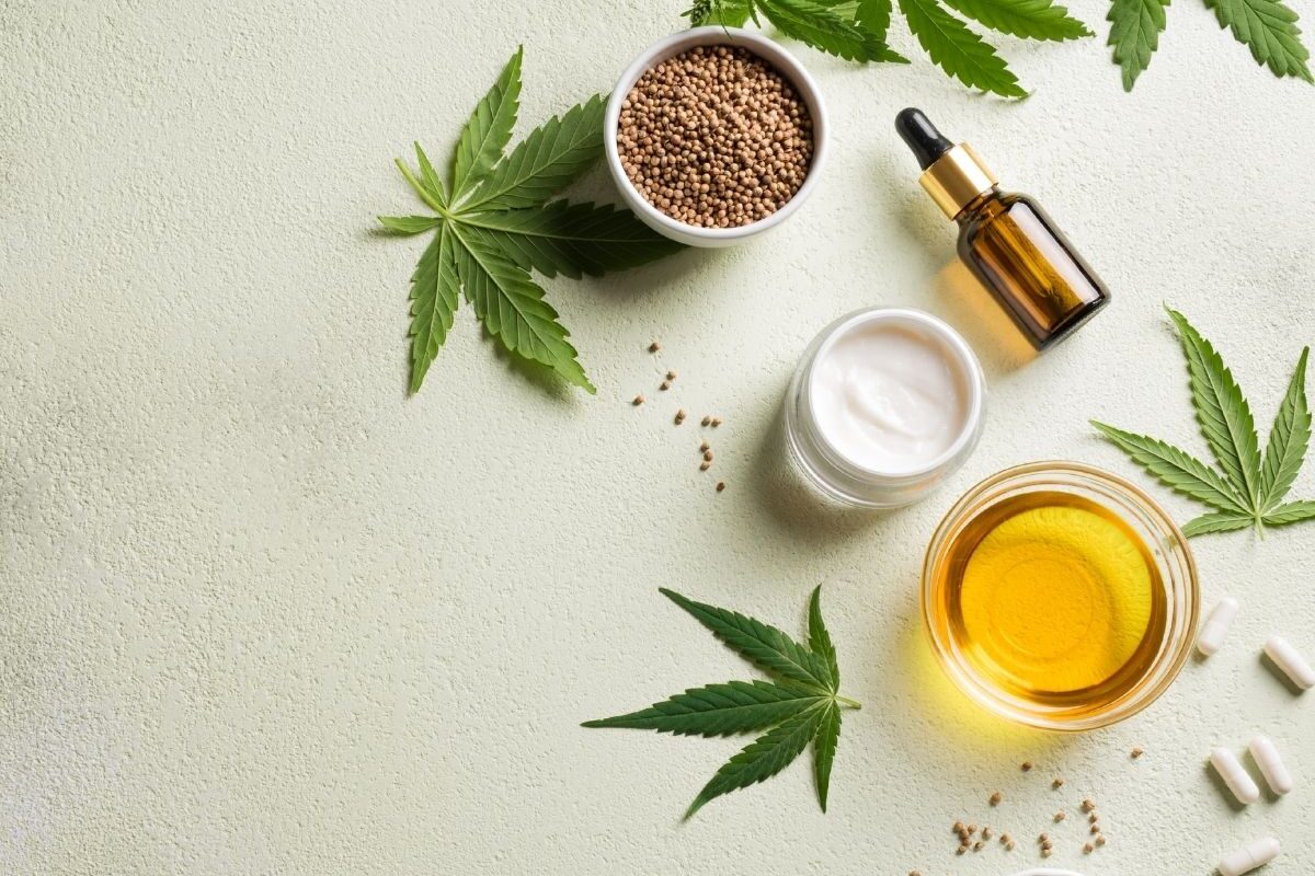 Hanfprodukte wie Öl, Kapseln, Samen und Creme auf hellem Hintergrund, symbolisieren die gesundheitsfördernde Wirkung von Hanf ohne Rausch